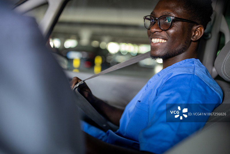 穿着医用工作服坐在车里的年轻人图片素材