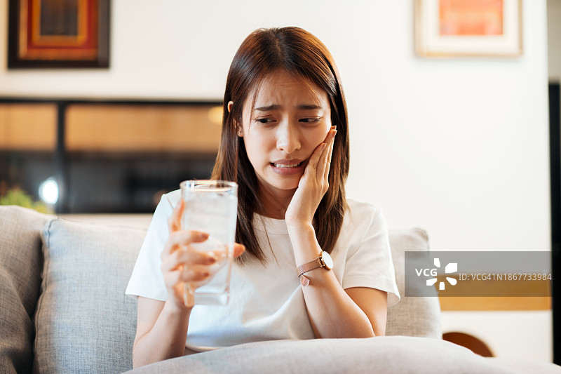 成年女人因饮用冰水后牙齿疼痛图片素材