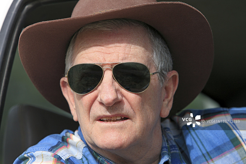 戴墨镜的农民从车里向外看图片素材