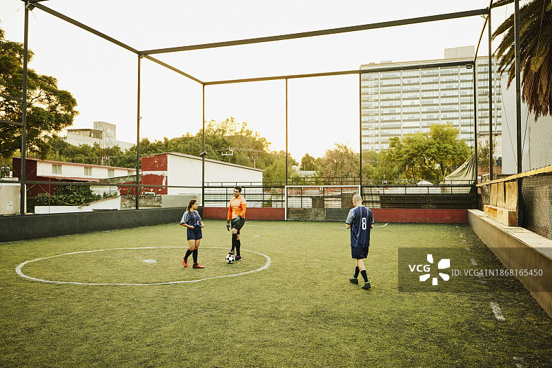 傍晚屋顶球场上的足球队友图片素材