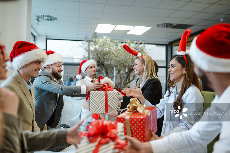 圣诞派对：同事间互赠礼物的温馨时刻图片素材