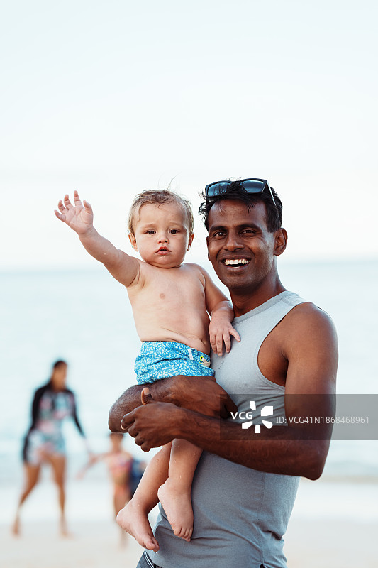 可爱幼儿与家人朋友在海滩玩耍图片素材