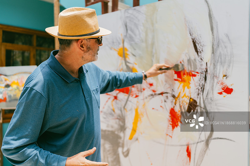 艺术家用画笔在画布上绘画图片素材