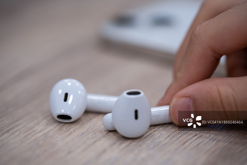 男孩拿着无线蓝牙耳机图片素材