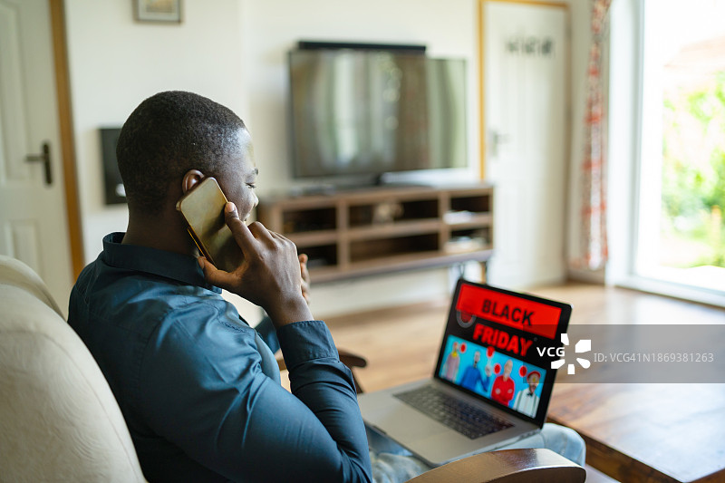 男子在笔记本电脑上看黑色星期五的优惠图片素材