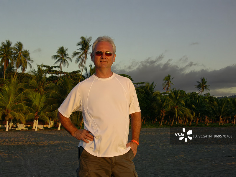 在哥斯达黎加西海岸海滩上戴着太阳镜的微笑男人肖像图片素材