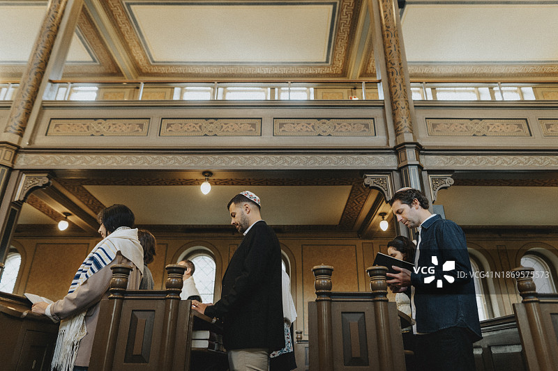 低角度拍摄人们在犹太教堂会众期间站立背诵《阿米达》图片素材