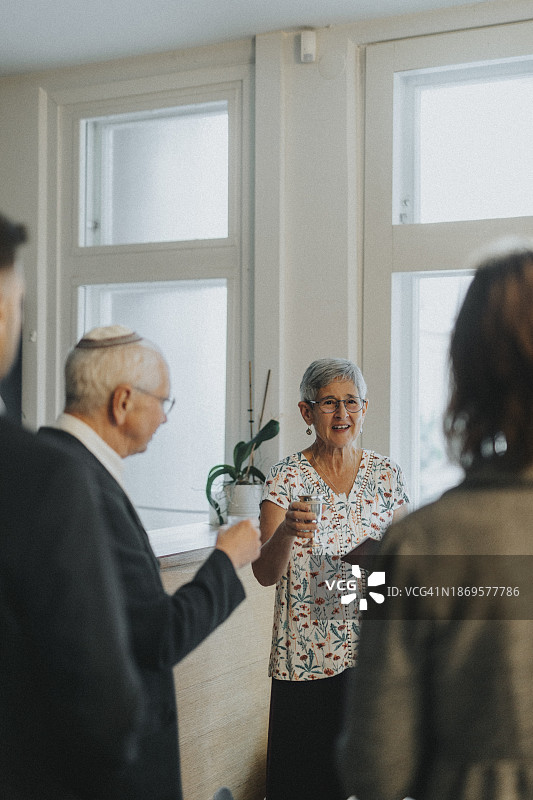 在犹太教堂的犹太教聚会期间敬酒的年长女性图片素材