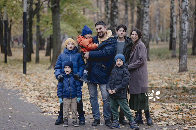 幸福的一家人在公园的树前合影图片素材