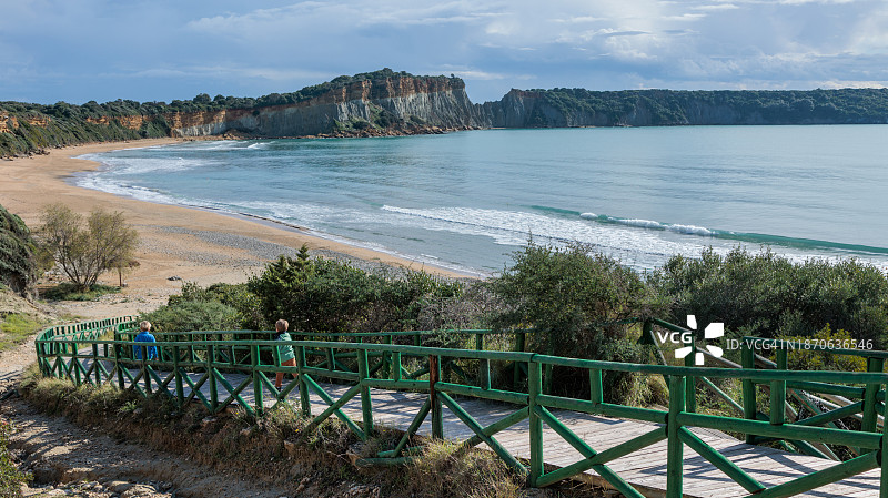 孩子们沿着木板路跑到希腊扎金索斯岛的Gerakas空旷海滩图片素材