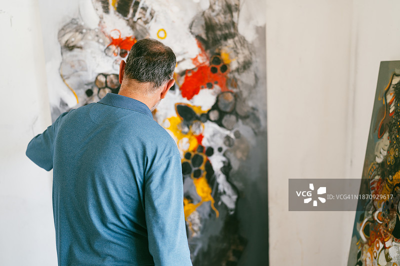 男人看着抽象画布图片素材