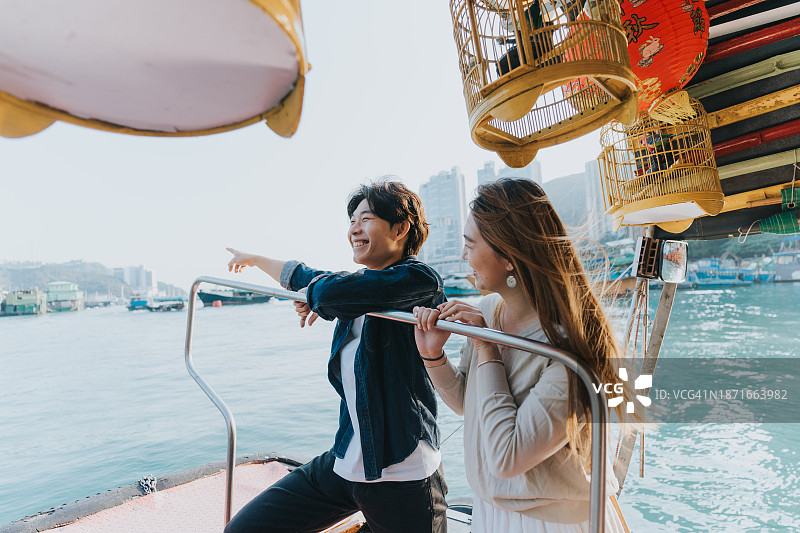 一对中国夫妇在舢板船上欣赏壮丽的景色图片素材