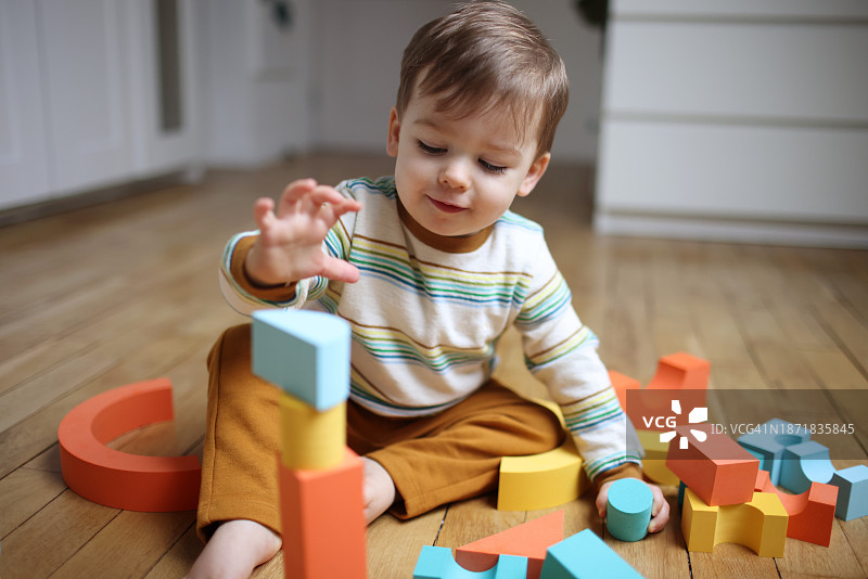 18个月男婴玩彩色积木图片素材