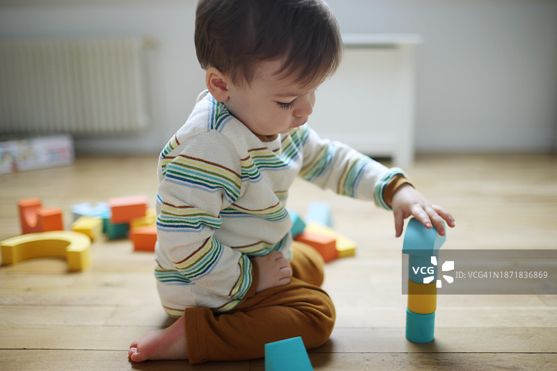 18个月男婴玩彩色积木图片素材
