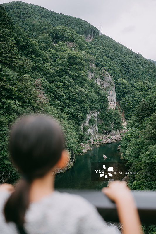 年轻女孩在峡谷中看河图片素材