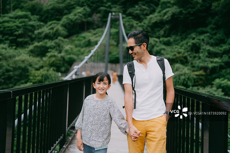 父女走在峡谷上的桥上图片素材