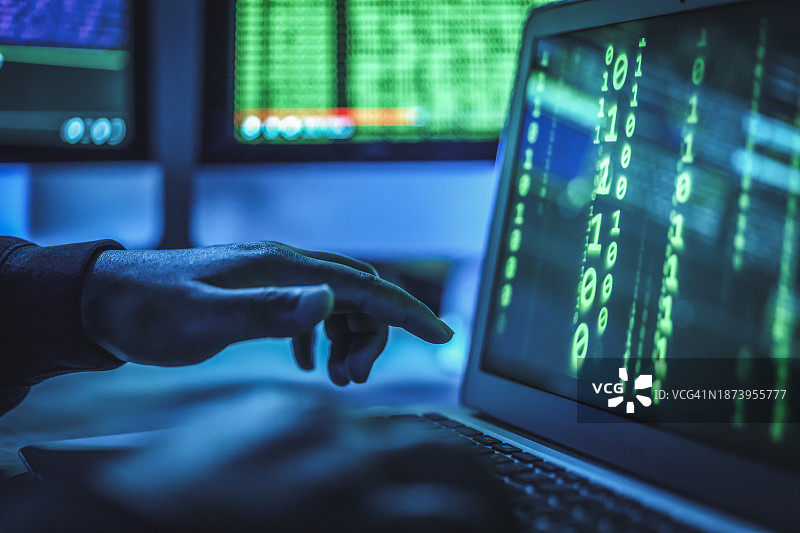 电脑程序员或黑客在笔记本电脑键盘上输入代码，试图侵入秘密组织系统图片素材