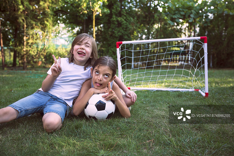 在后院准备踢足球的快乐可爱孩子们图片素材