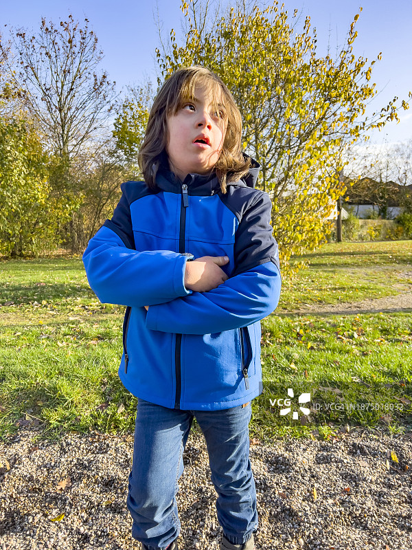 患有唐氏综合征的男孩交叉双臂摆姿势图片素材