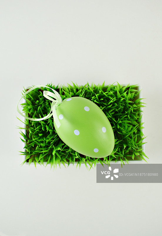 白色背景草地上的绿色复活节彩蛋玩具图片素材
