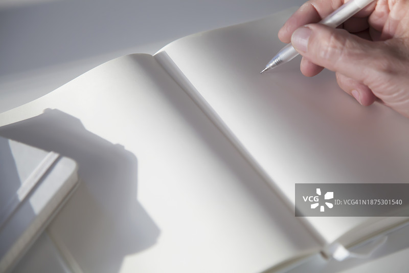 男人在笔记本空白页上握着铅笔图片素材