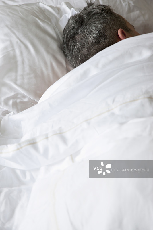 在床上睡觉的男人的背影图片素材