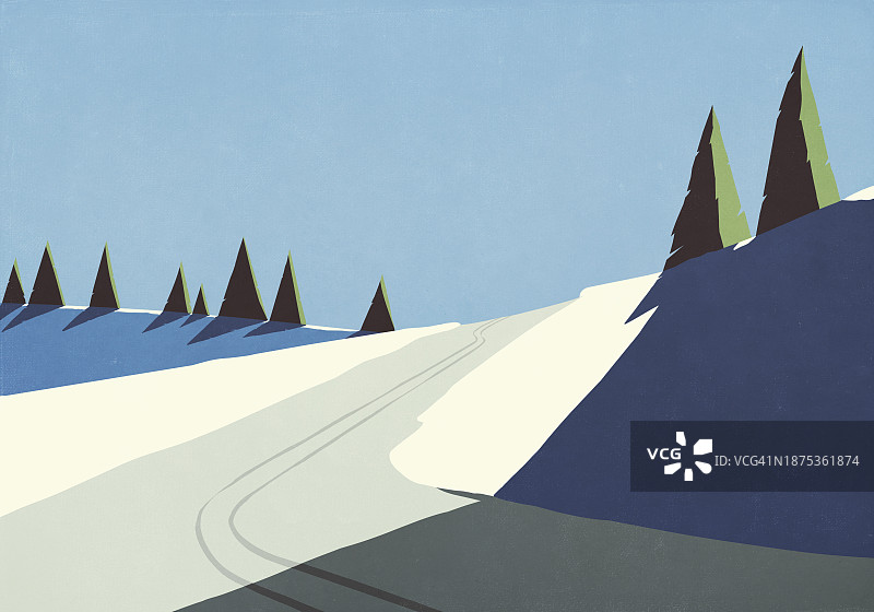 阳光照亮偏远山坡上雪地中的滑雪痕迹图片素材