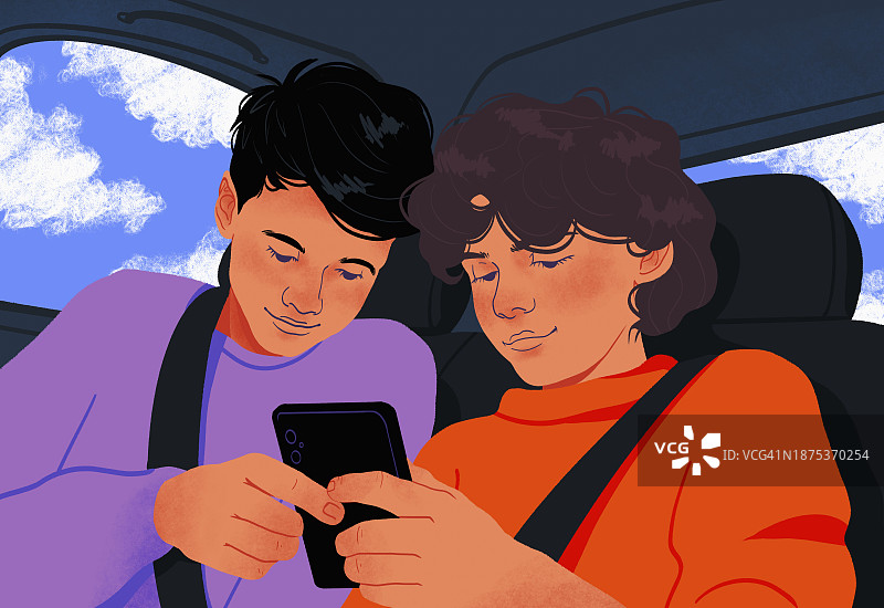 坐在汽车后座一起使用智能手机的少年兄弟图片素材