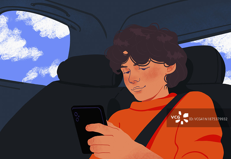 在汽车后座玩智能手机的男孩图片素材