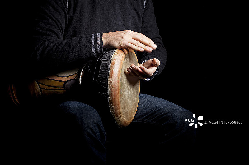 男子坐在黑色背景前抽烟的身体中部照片图片素材