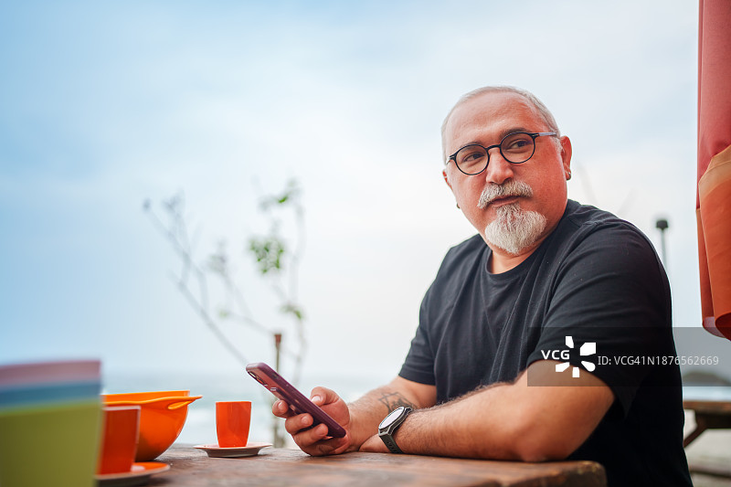男人在野餐桌旁使用手机图片素材