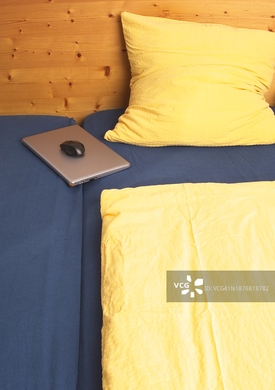 床上笔记本电脑、床单、枕头和被子图片素材