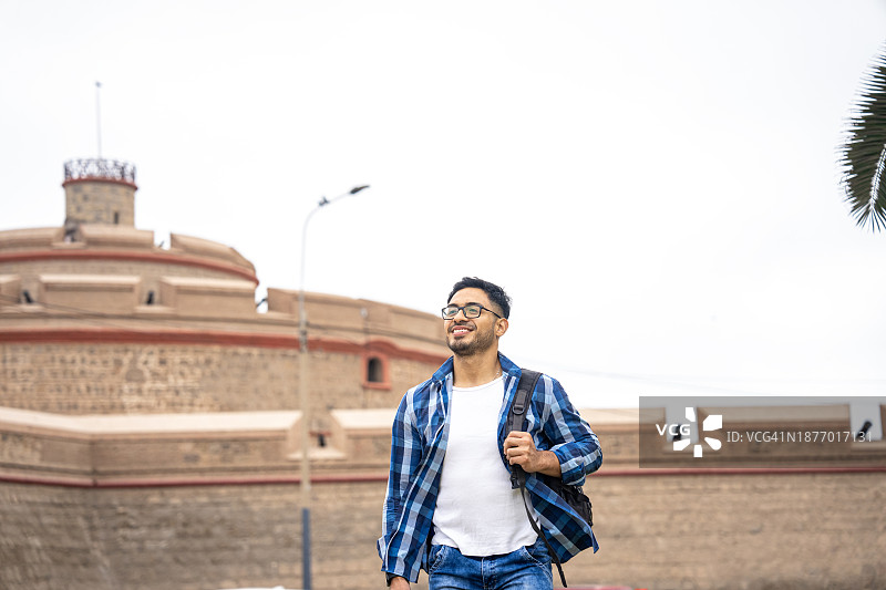 年轻的西班牙裔男子在秘鲁卡亚俄皇家费利佩堡漫步图片素材