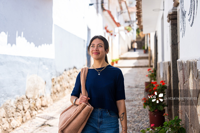 在秘鲁库斯科圣布拉斯街头观光的年轻女子图片素材