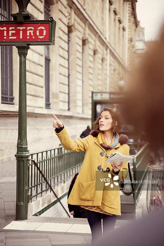 在巴黎地铁附近寻找方向的时尚年轻游客图片素材