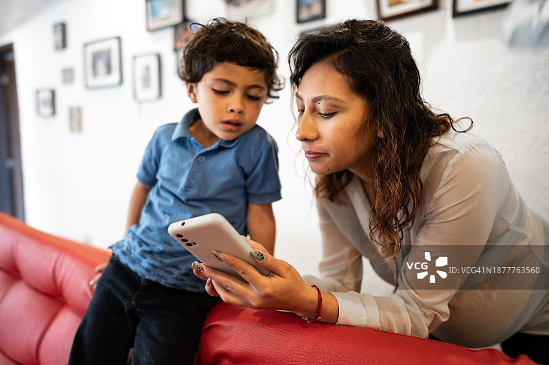 孕妇在家向儿子展示手机图片素材