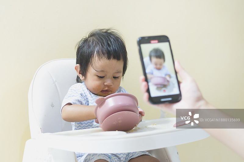 亚洲女婴自己进食的瞬间图片素材