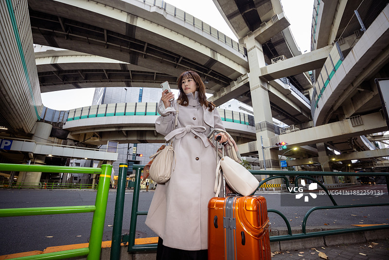 商务女人在城市使用智能手机 - 低角度视图图片素材