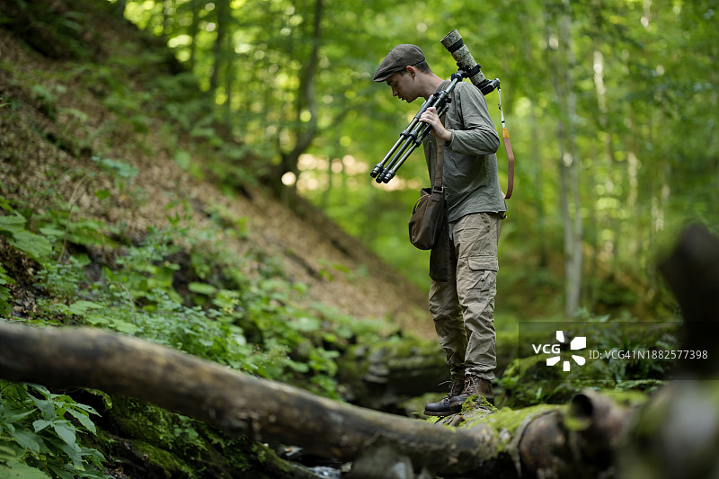 摄影师携带三脚架相机行走图片素材