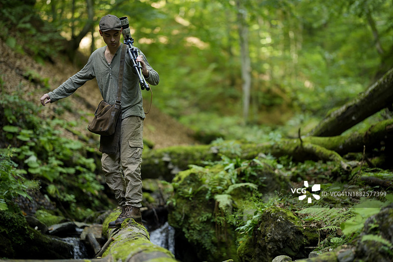 摄影师携带三脚架相机行走图片素材
