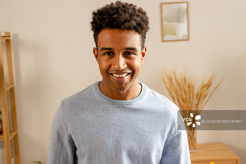 在家中留着非洲发型的英俊年轻人肖像图片素材