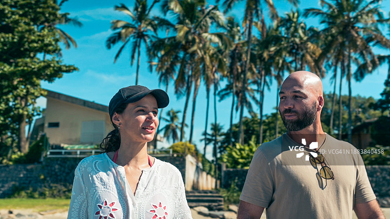 情侣抵达海滩，背景是棕榈树图片素材