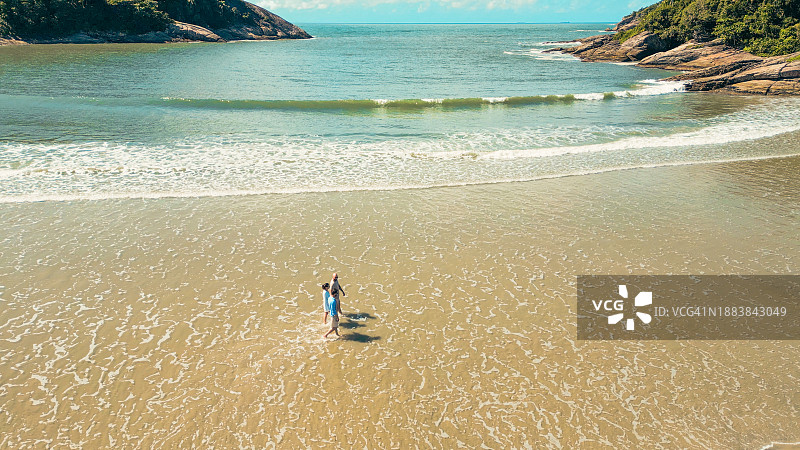 朋友们在海滩上散步航拍图片素材