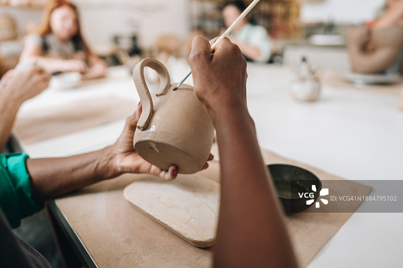 特写：女人在陶瓷工作室制作茶壶图片素材