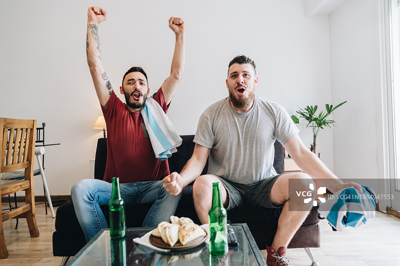 足球迷朋友们在家看电视直播足球比赛图片素材