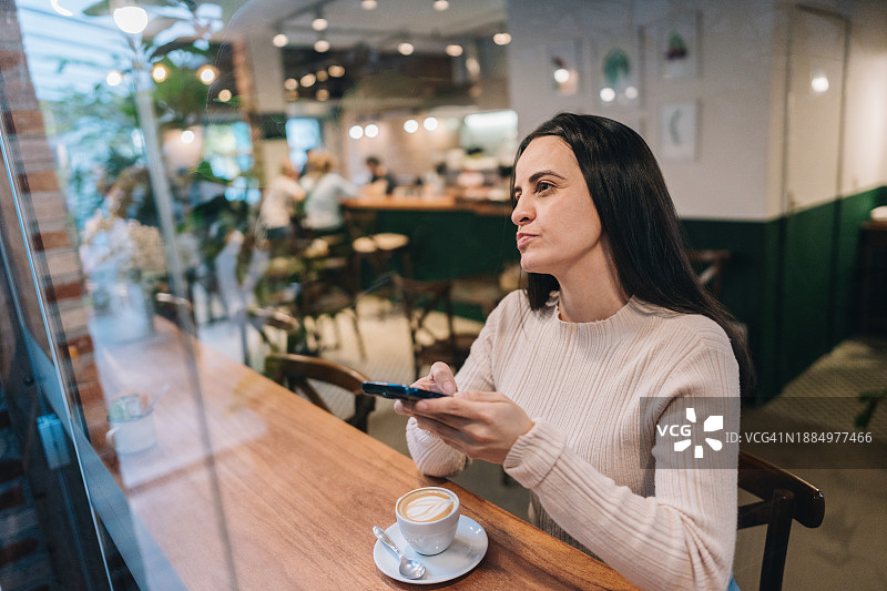 中年妇女在咖啡店靠窗而坐图片素材