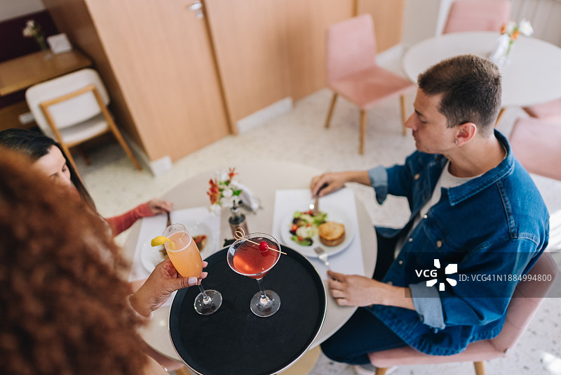 女服务员在餐厅为顾客提供饮品图片素材