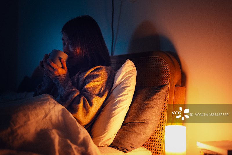 年轻的亚洲女性睡前喝茶图片素材
