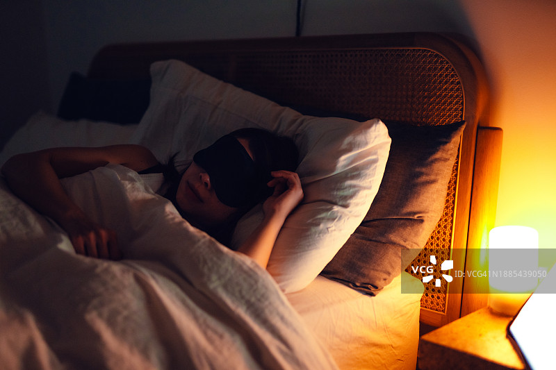 疲惫的女人在漫长的一天后戴着眼罩睡觉图片素材