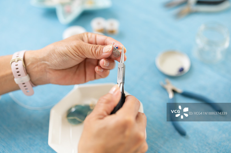 在家里的房间里制作配饰的女子图片素材